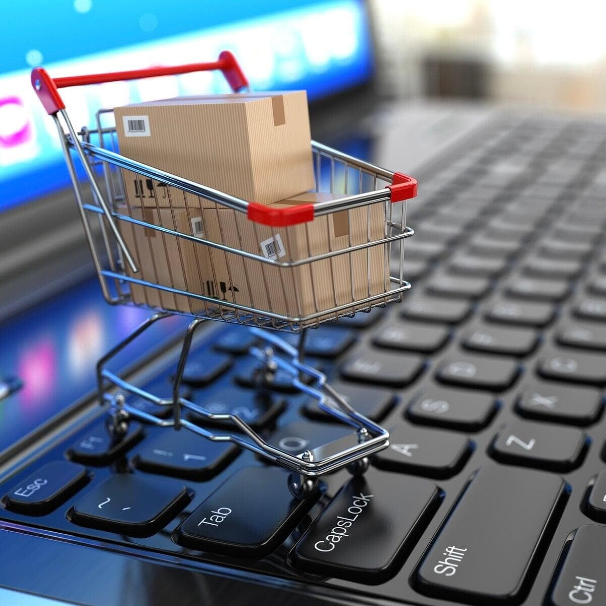 shopping trolley cart holding boxes on a laptop keyboard