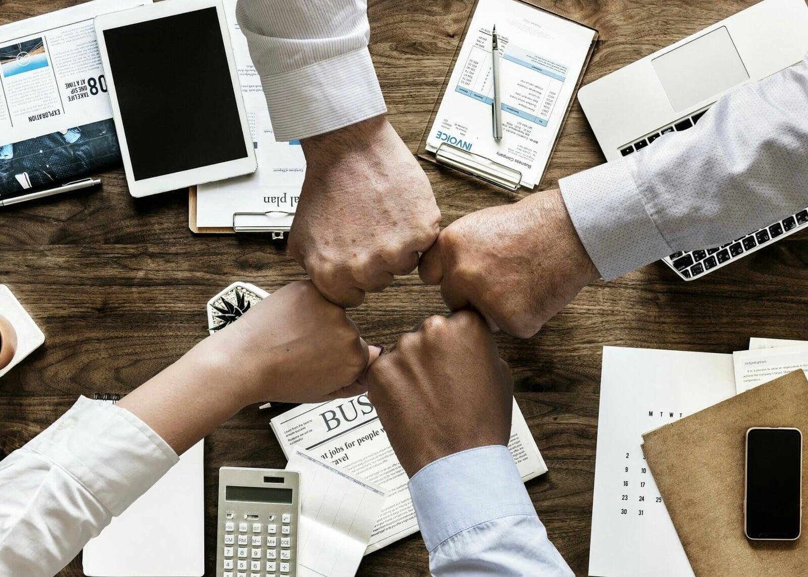 group of four team work fist bump business
